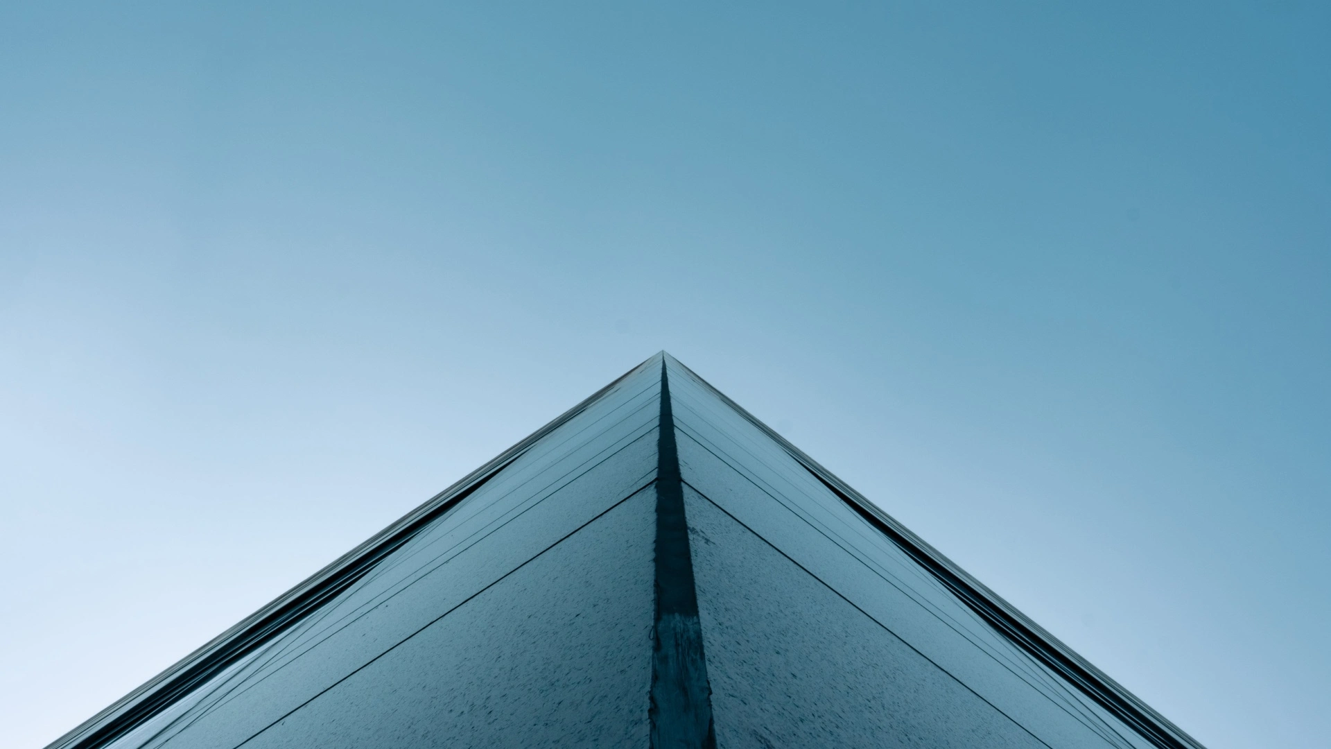 Modern concrete architecture angle against a blue sky, symbolizing solid foundations for SaaS UX maturity and scalable growth.